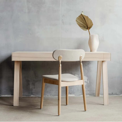 Modern wooden ash desk in a scandi design with chair against a concrete wall