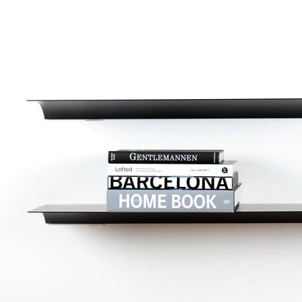 Black metal shelf with books titled 'Gentleman', 'Latted', and 'Barcelona Home Book' on a white background