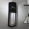 Modern black wall clock with pendulum design on a gray wall