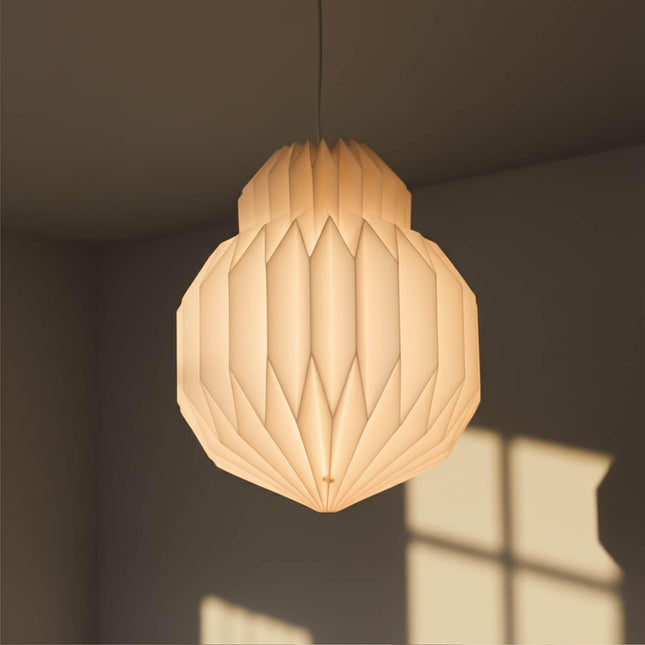 bulb origami paper lampshade hanging from the ceiling with light on