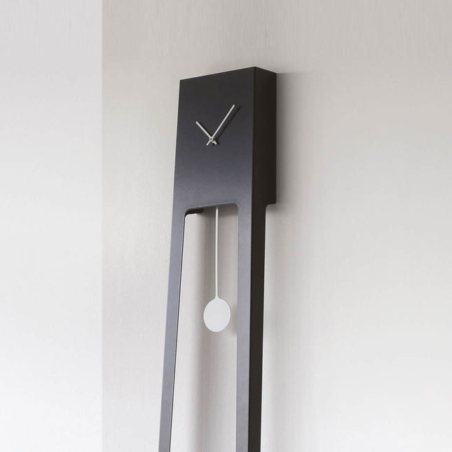 Tiuku Modern wall clock in black finish with long pendulum on a light gray background