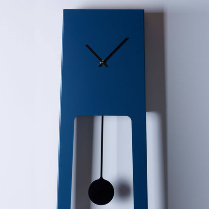 Blue wall clock with black hands and pendulum on a white background