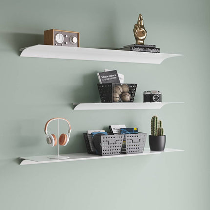 White metal shelves against a green wall with various items on them in a modern japandi style