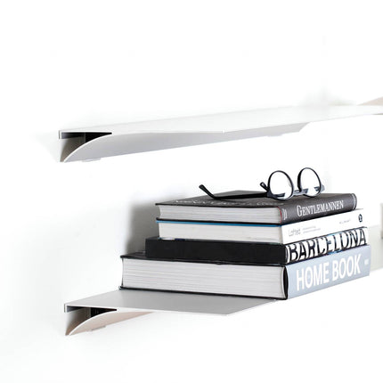 Stack of books on a white metal shelf with a white background