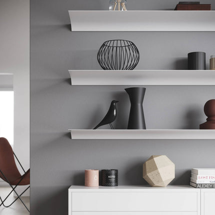 White metal shelves with decorative items against a gray wall