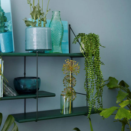 close up detail image of the solid wood shelf painted in green with ornaments displayed on shelf