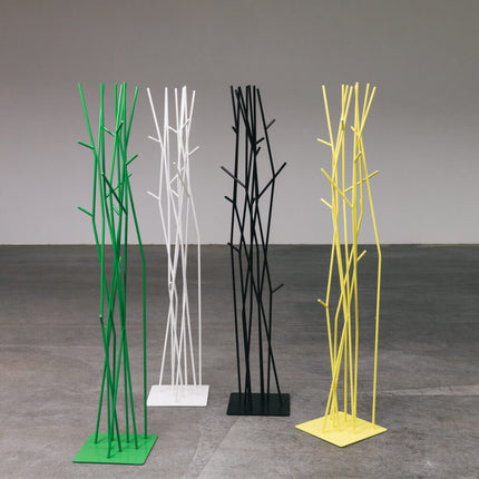 Four modern coat racks in green, white, black, and yellow on a gray floor with a gray background.