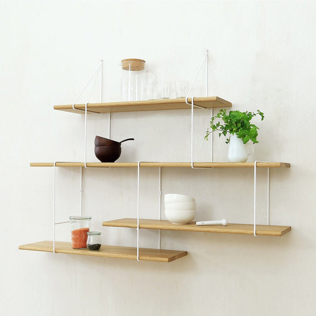 tiered oak shelving on a white wall