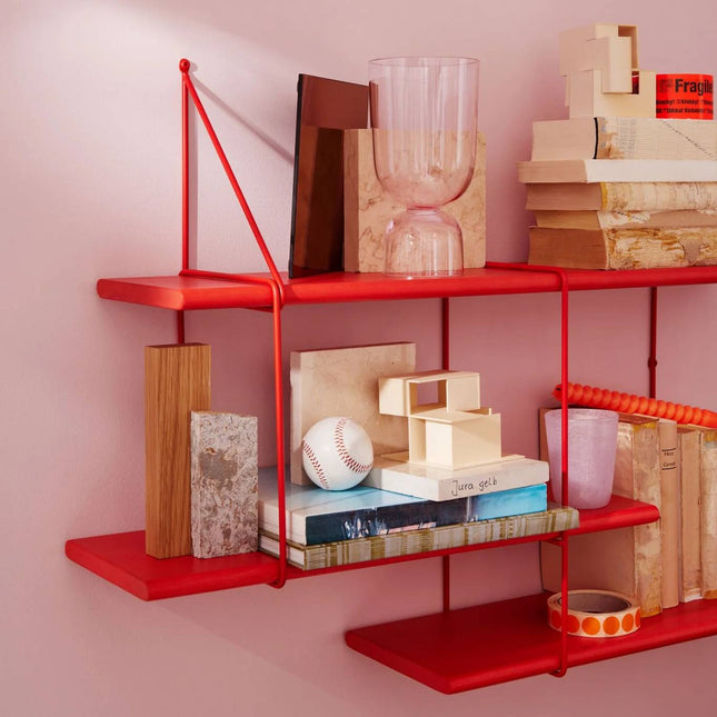 close up detail image of the solid wood shelf painted in red with ornaments displayed on shelf