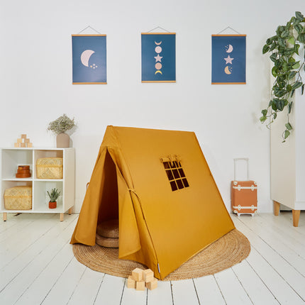 Mustard yellow tent with window cutout on a white floor, surrounded by decor items.