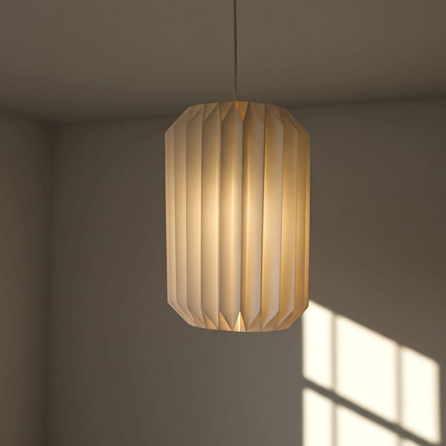 tube shaped origami lampshade hanging with light on