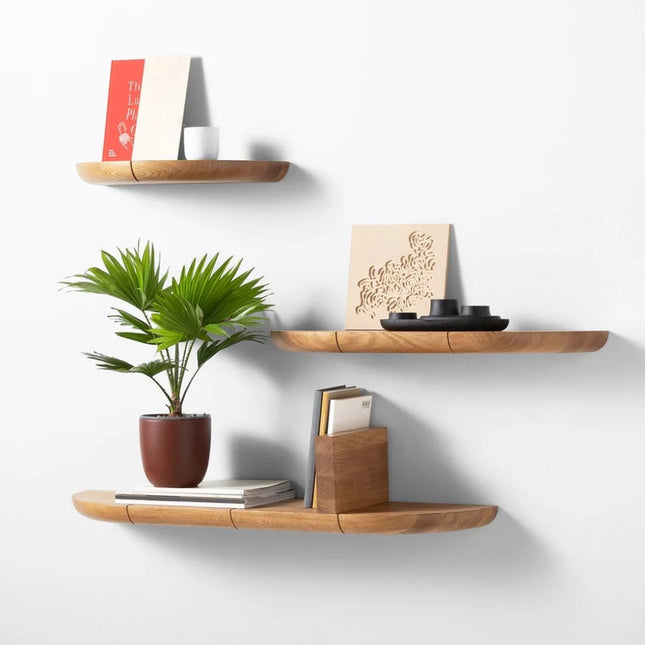 Oak wooden shelves with decorative items on a white wall