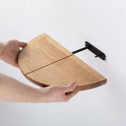 Wooden paragraph shelf and black back bracket held by a hand on a white background
