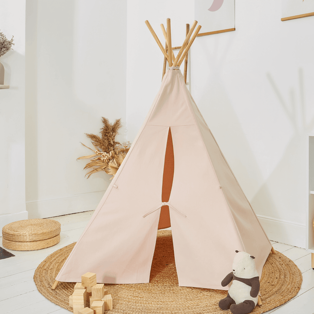 closed pastel pink teepee with teddy bear and building blocks in childs bedroom