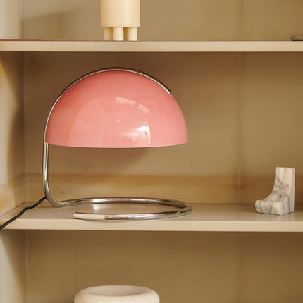 Retro 70s Pink table lamp on a wooden shelf with a neutral background
