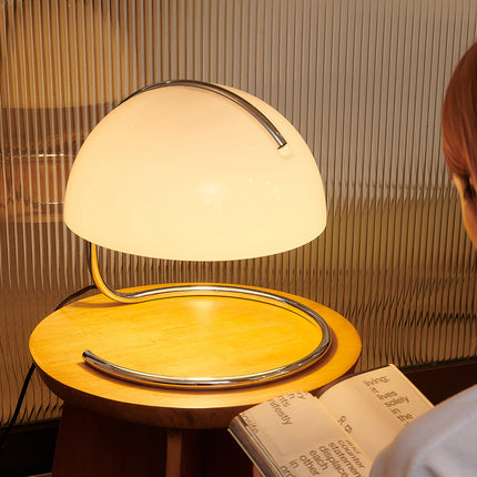 Retro 70s style table lamp with Person reading a book next to a modern table lamp with a wooden base.