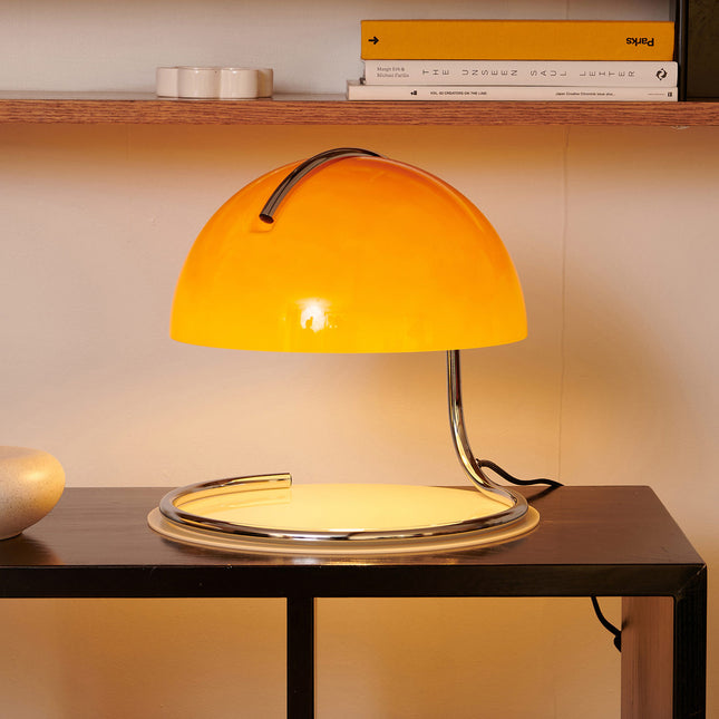 Yellow glass table lamp in 1970s style 
on a wooden surface with a blurred background