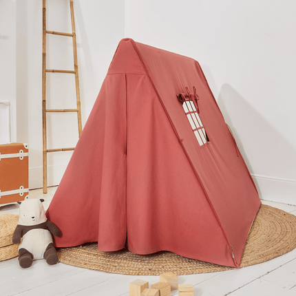 Pastel Red children's play tent with wooden blocks and a teddy bear on a white floor.