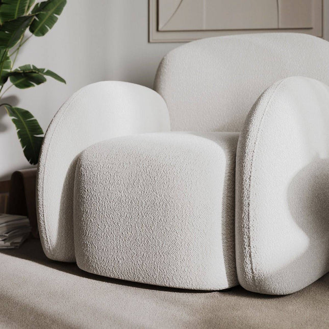 Modern white armchair in a room with a plant and neutral decor