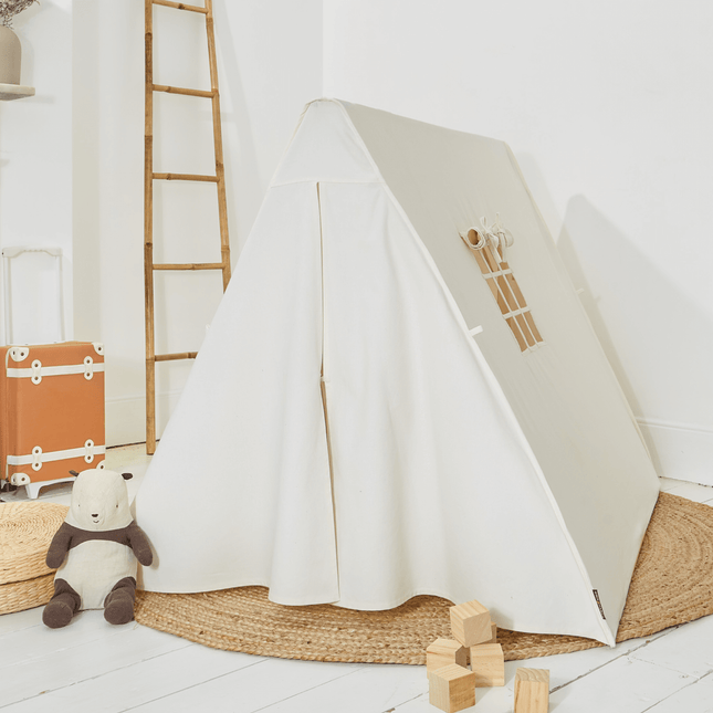 White children's play tent with wooden blocks and a teddy bear on a light wood floor.