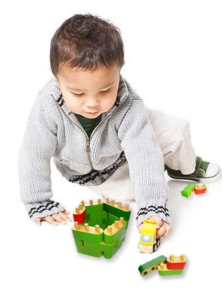 kid playing with wooden building blocks 