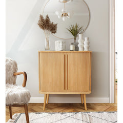 Wooden tambour highboard with decorative items in a room with a chair and mirror.