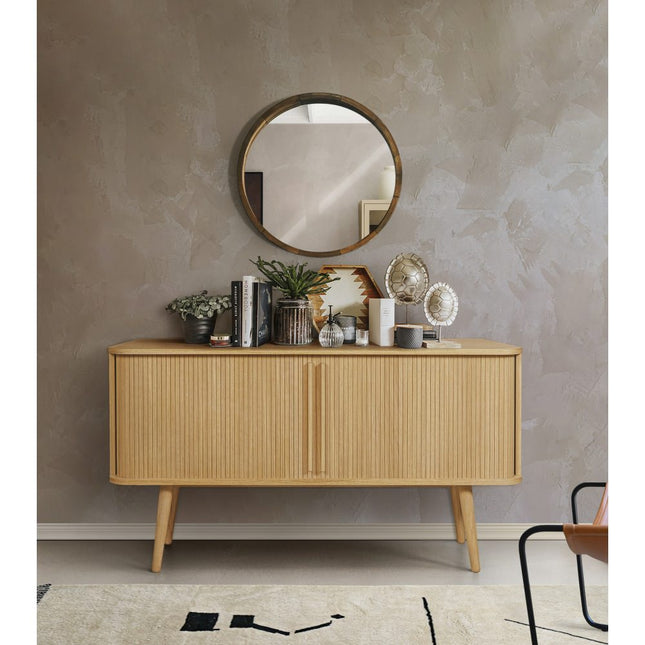 Wooden tambour sideboard with decorative items against a grey wall